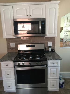 a stove and overhead microwave in a remodeled kitchen in Southgate